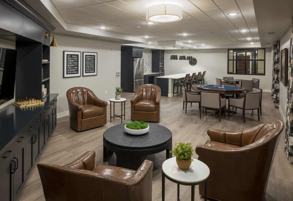 Comfortable lounge with leather chairs and game tables for residents at Lyngblomsten