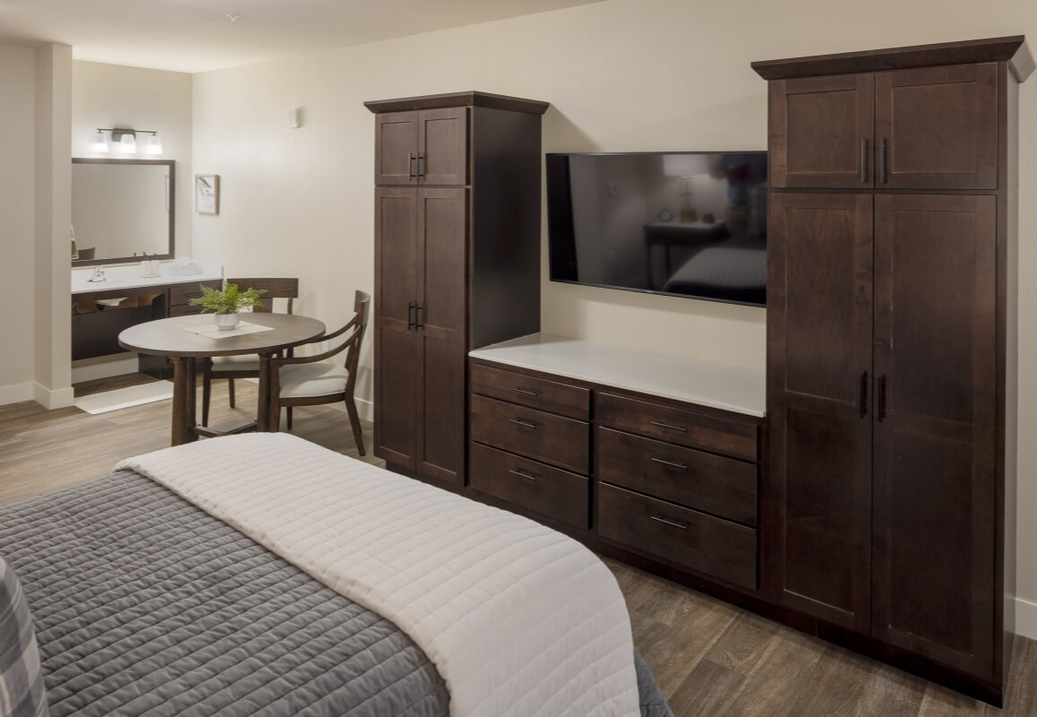 Guest suite with bed, dining area, and entertainment center, and bathroom.