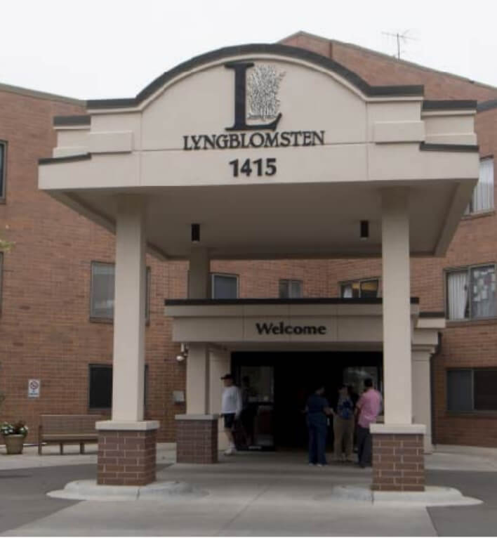 The main entrance of Lyngblomsten Care Center with a covered drop-off area and welcome sign.
