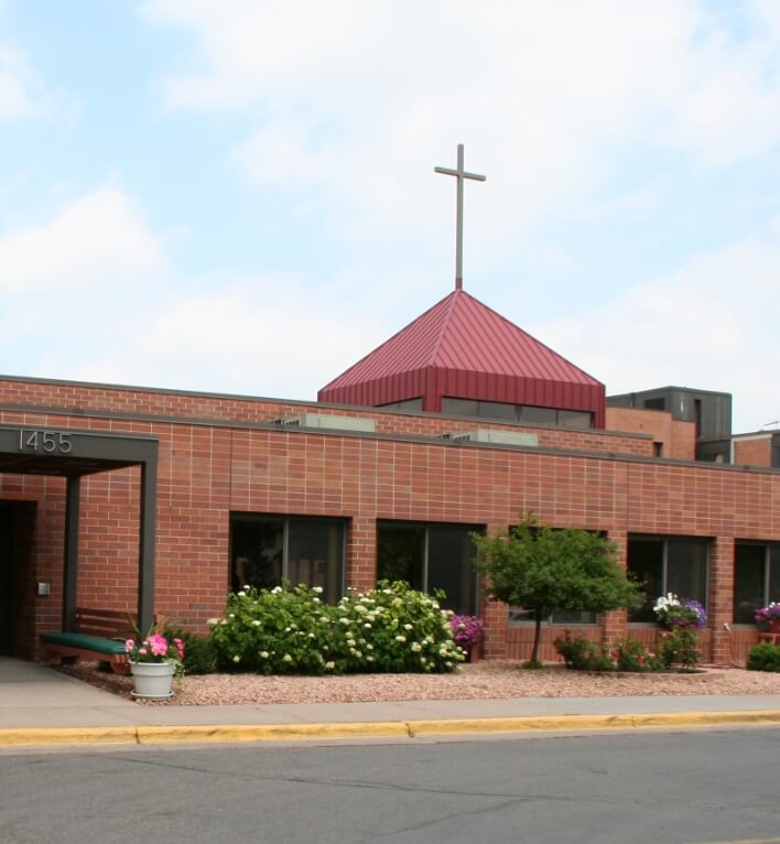 Exterior view of the Lyngblomsten chapel, featuring a red roof and cross on top.