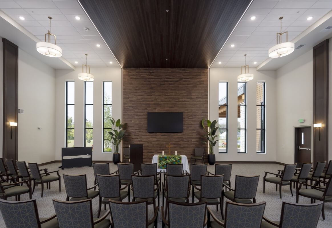 Chapel with rows of chairs and tall windows at Lyngblomsten campus