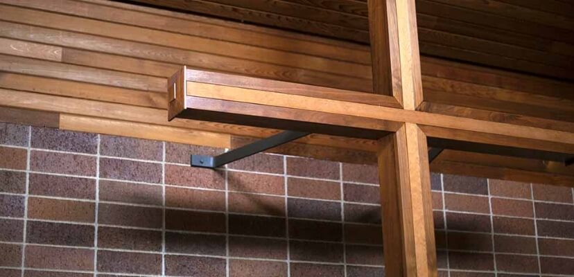 A wooden cross mounted on a brick wall inside a chapel at Lyngblomsten.