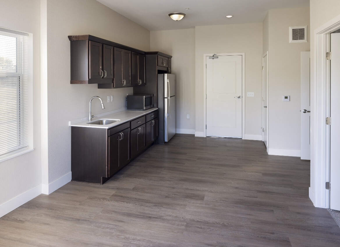 Kitchenette in a Memory Care suite with dark cabinetry