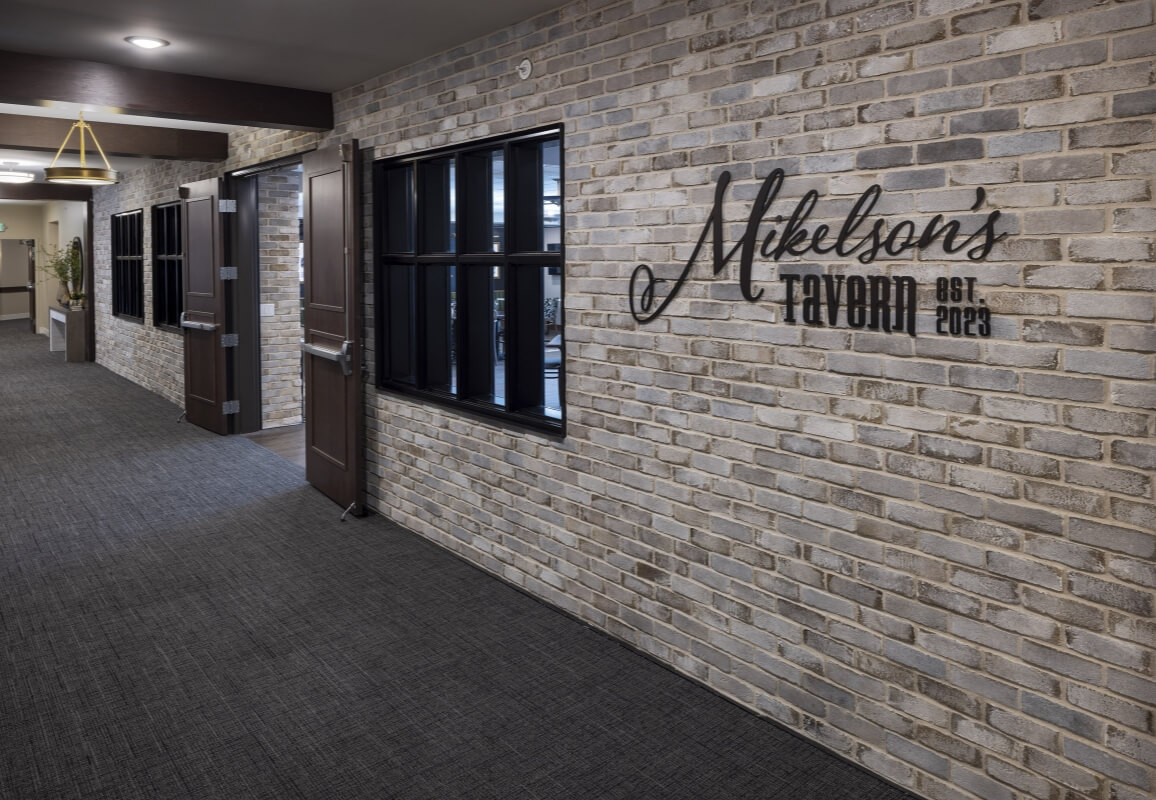 Brick hallway with signage for Mikelson’s Tavern, established 2023
