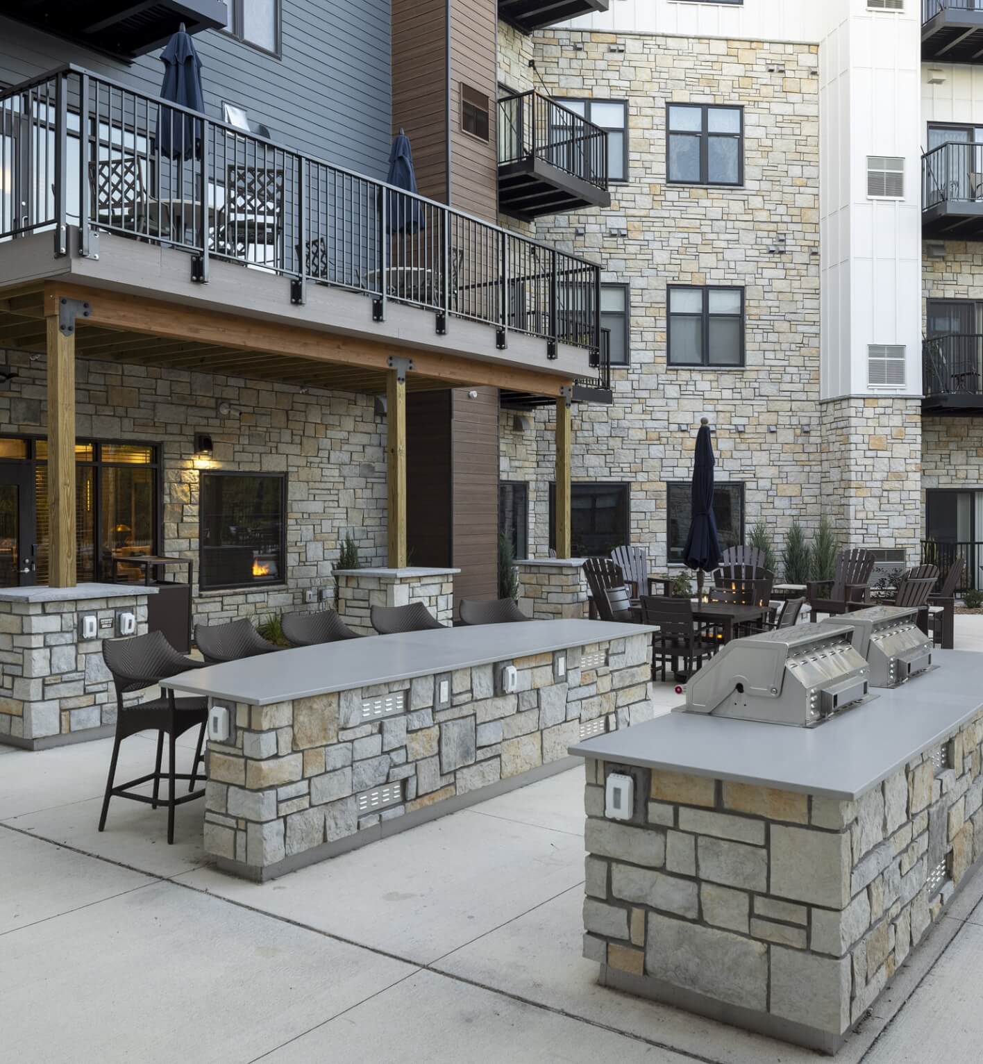 Outdoor grilling stations with stone counters and seating