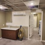 A room under renovation with an unfinished ceiling, a countertop, and construction equipment in a senior living facility.