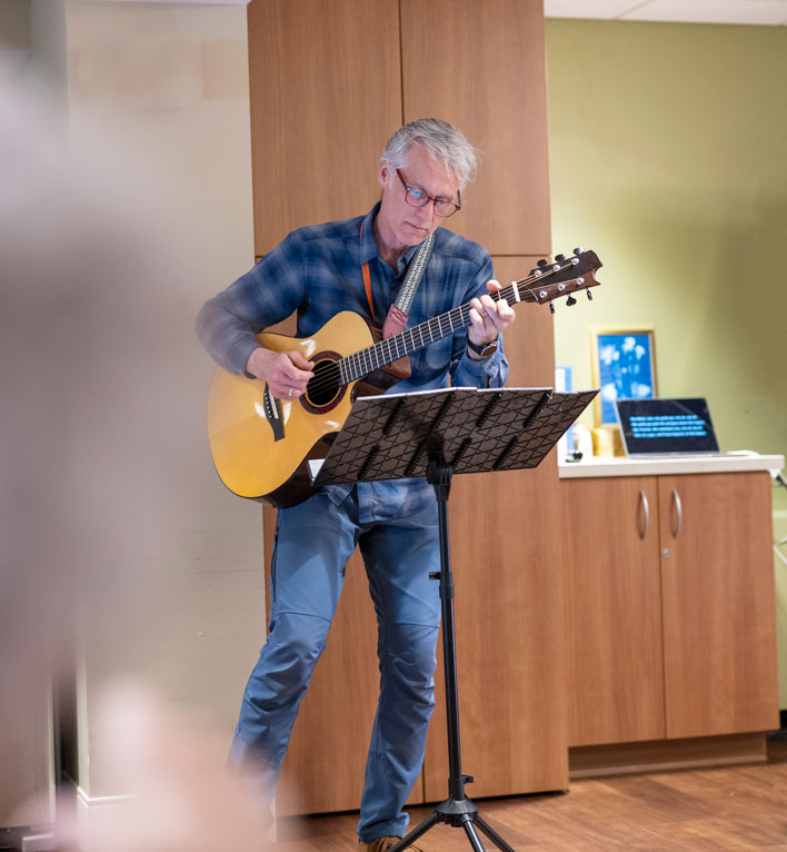 MacPhail teaching artist playing guitar and singing songs for residents of the Lyngblomsten Care Center in Como Park.
