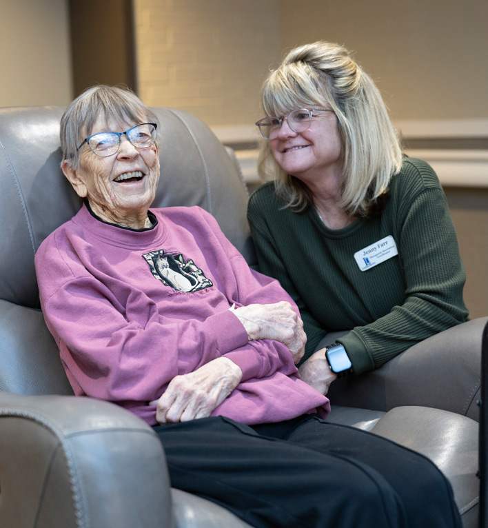 Therapeutic Recreation Coordinator sings a song with a care center resident as they listen to music from the room next door.