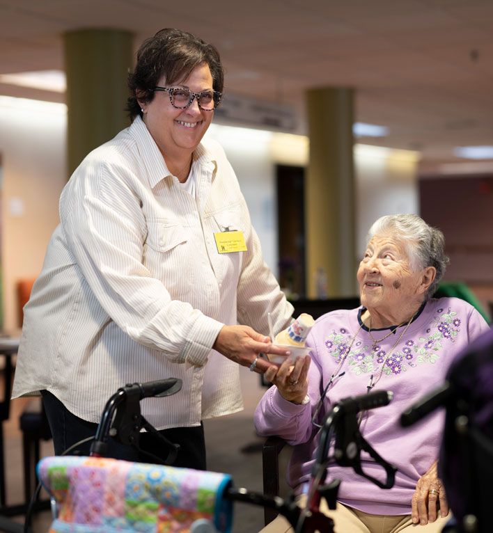 A volunteer hands her mother an ice cream cone while volunteering at Anna's café and gifts.