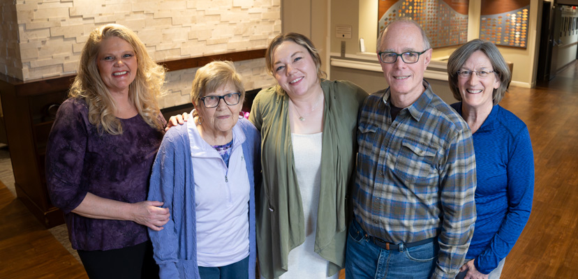 A caregiver specialist smiles with some of the caregivers she helps and their loved ones who participate in The Gathering.
