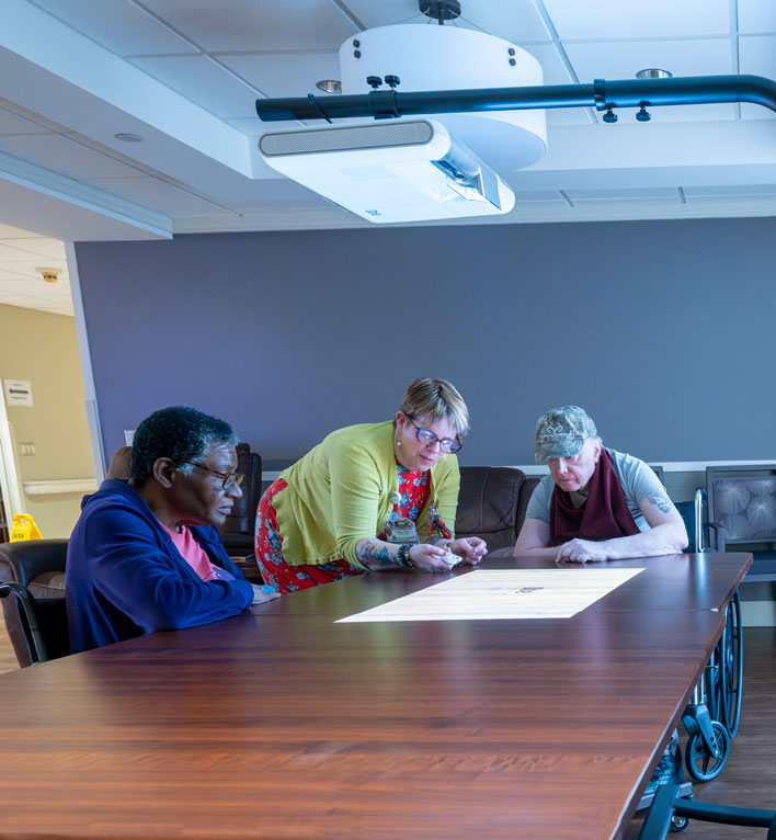 Lyngblomsten Care Center Residents playing games using virtual reality technology with therapeutic recreation staff.