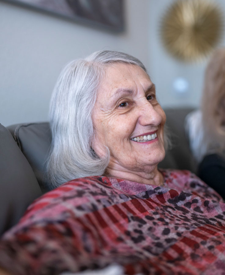 Assisted Living resident smiling and looking off into the distance.