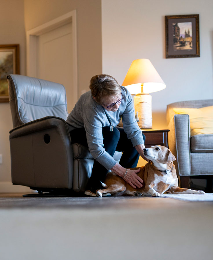 Independent living resident pets and talks to her dog in her living room.