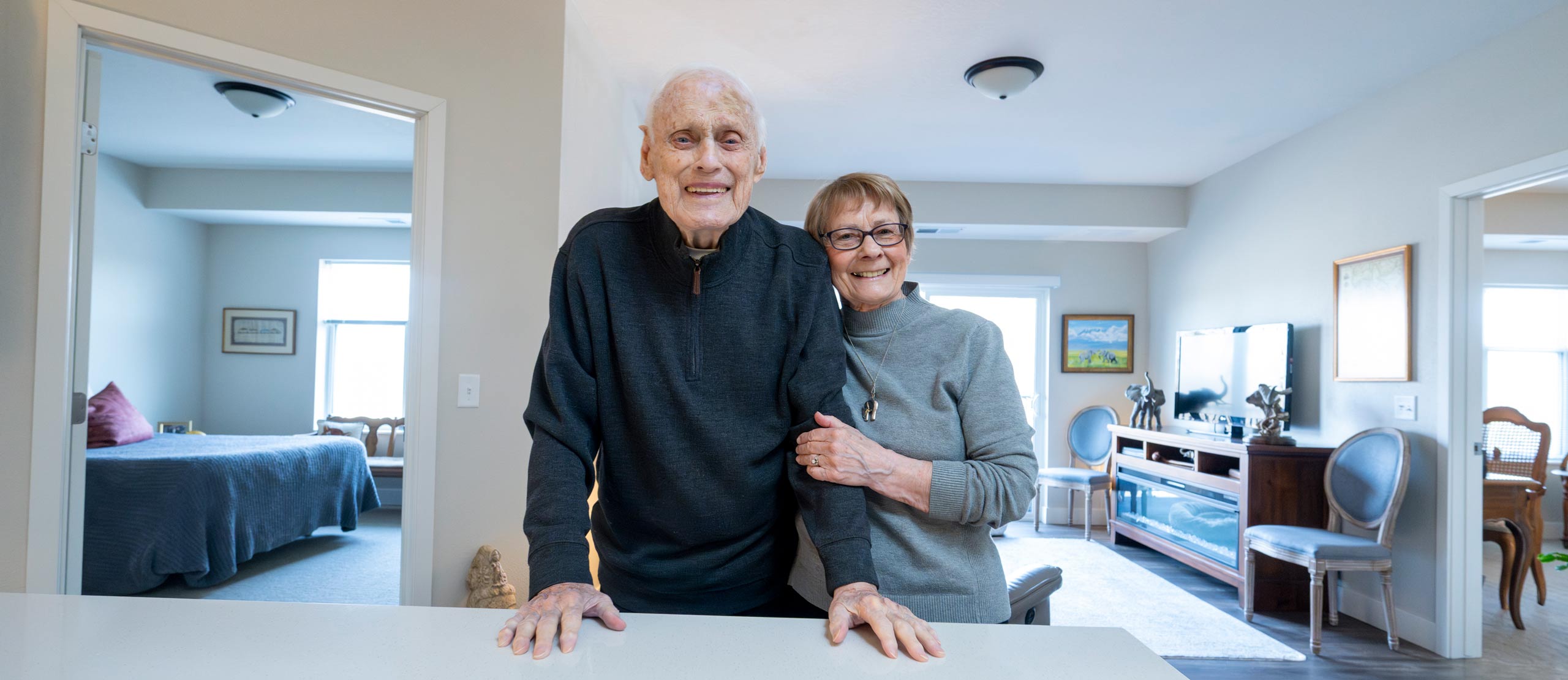 An independent living couple posing in their living room for a photograph.