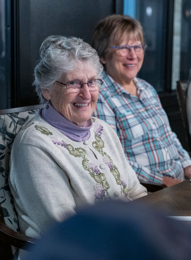 Residents enjoy each other's company before dinner at the large dining table in Wally's restaurant.