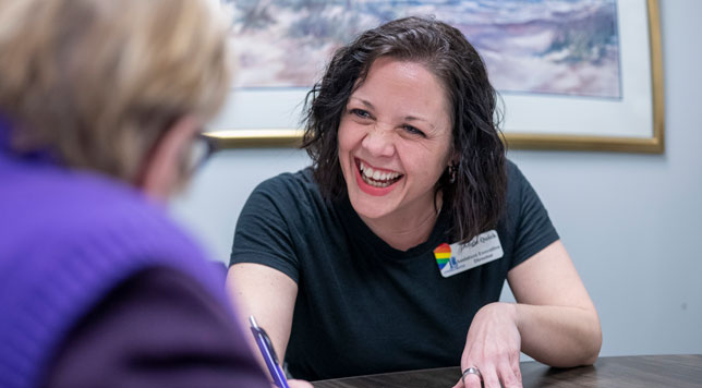 The Executive Administrative Assistant smiles her signature smile at a potential resident.