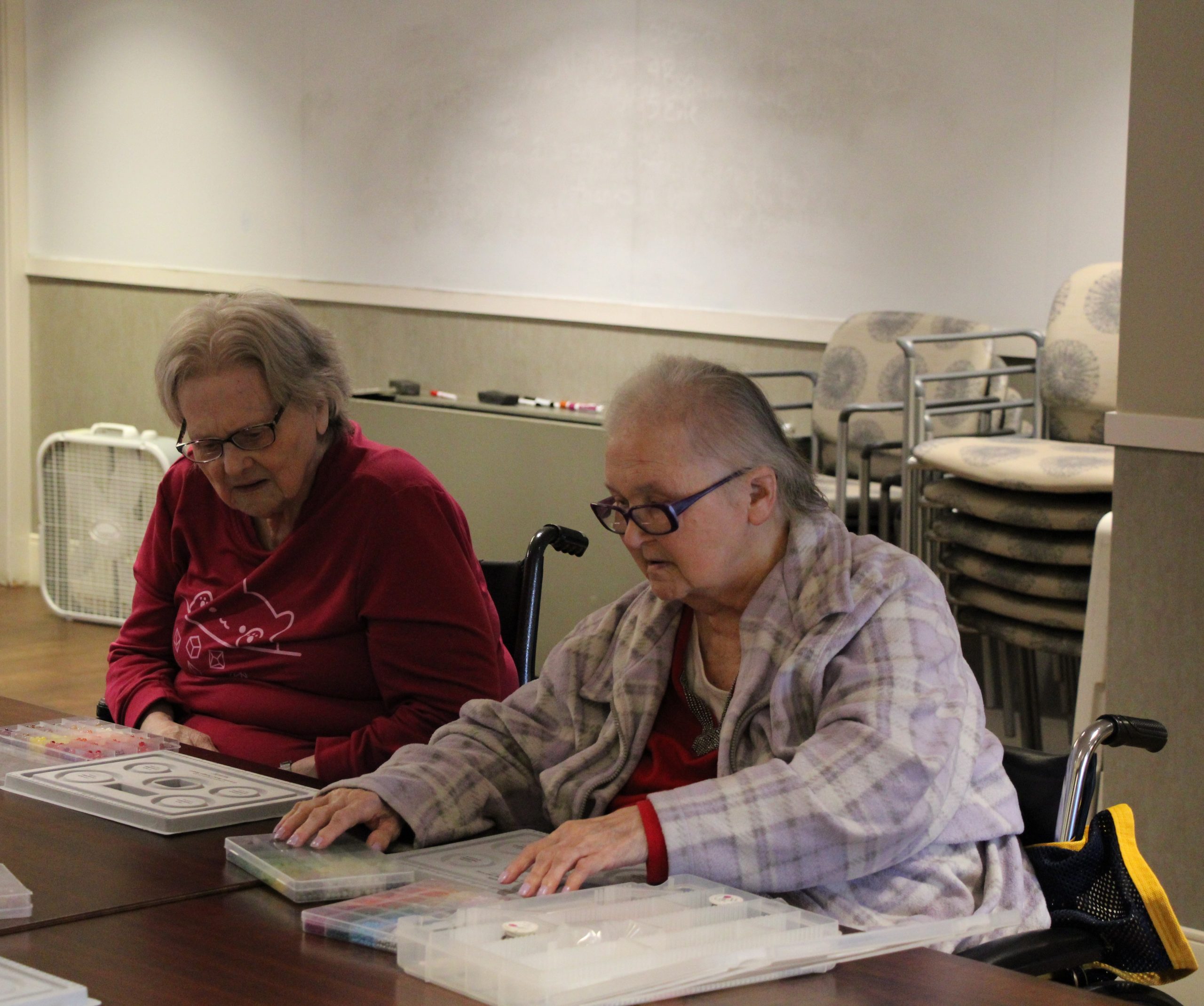 Two residents making bracelets in the Care Center