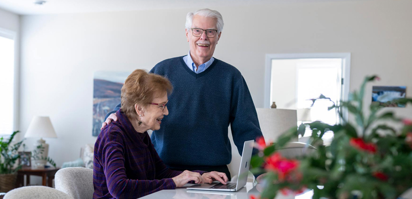 Townhome couple at the kitchen counter looking at their laptop.
