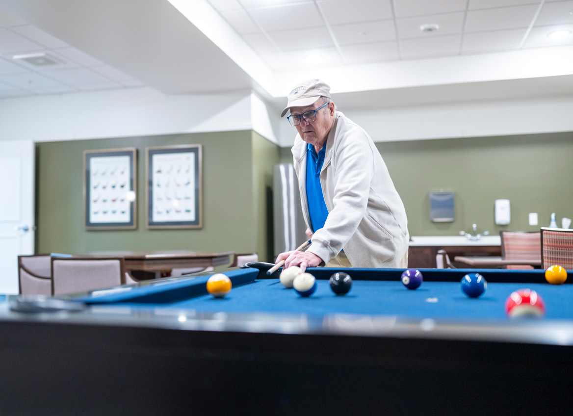 A Resident Takes Aim as he Plays Pool in the Game Room