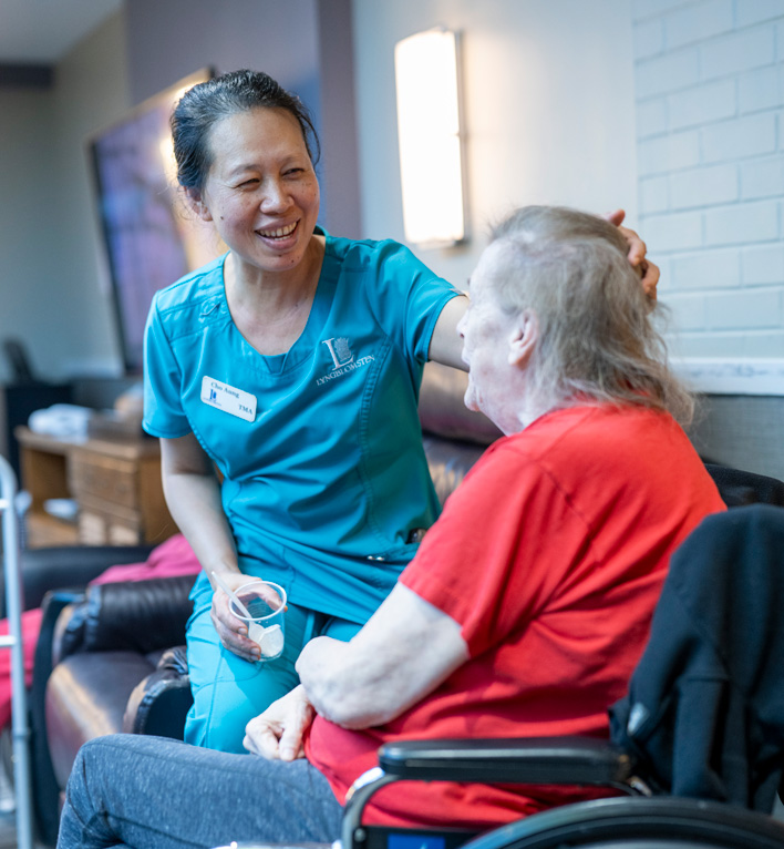 Care Center Employee with Care Center Resident in a Wheel Chair