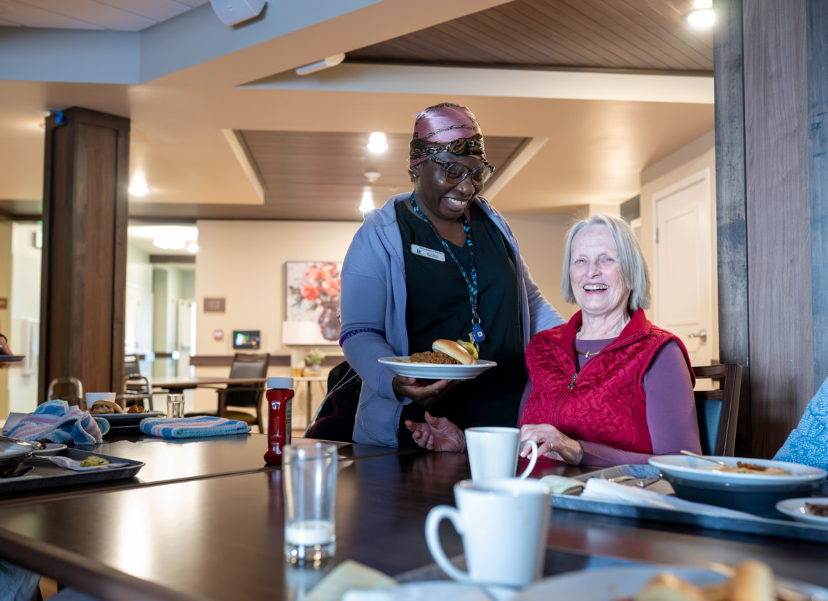 Employee Hands an Assisted Living Resident a Meal