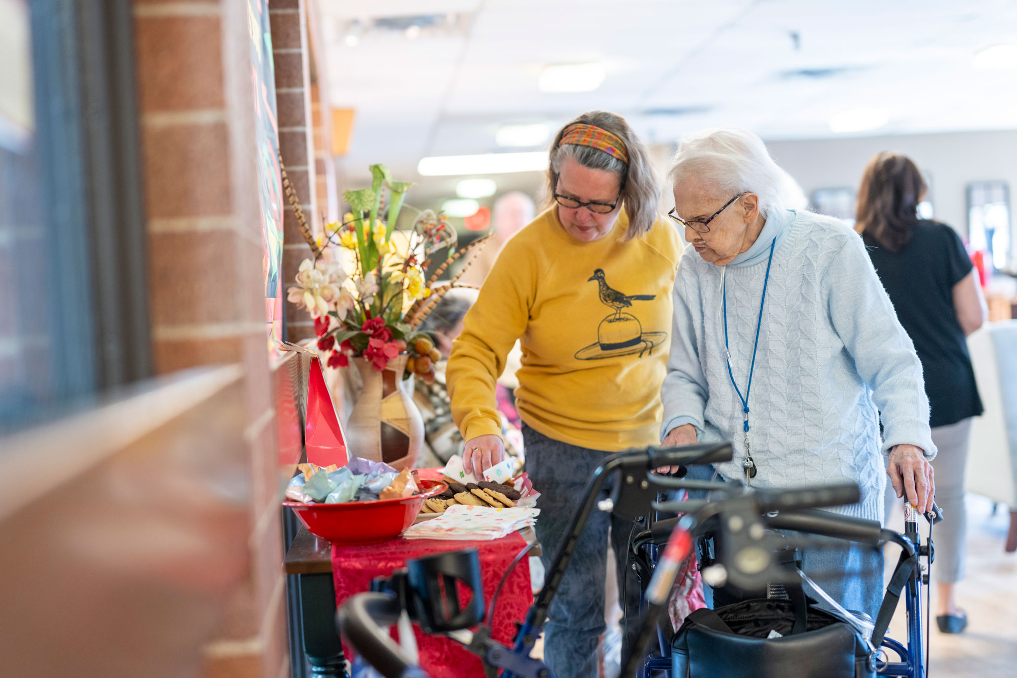 Lyngblomsten Resident and Family Member Grabbing Cookies in the Lobby of The Apartments