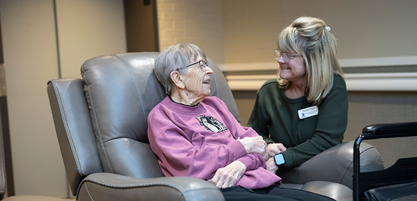Therapeutic Recreation Employee Sitting with Resident